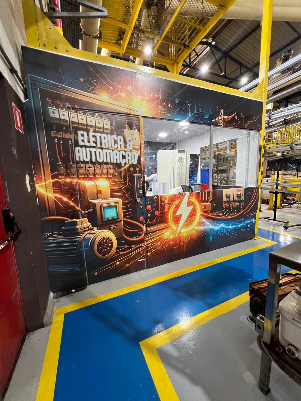 Adesivação de painéis em área industrial, com ilustrações de máquinas e automação.