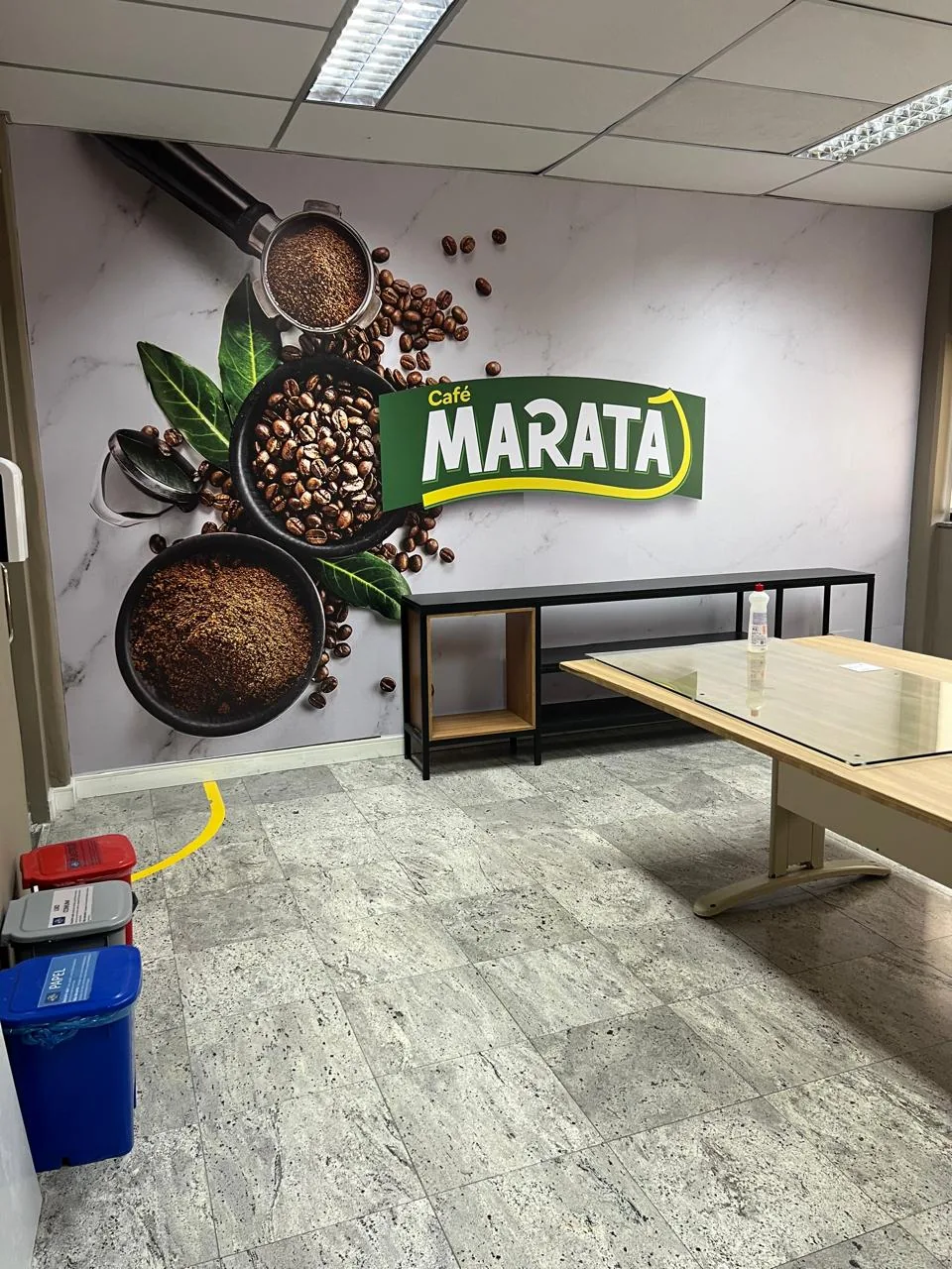 Adesivação de parede com marca de café e ilustrações de grãos em espaço interno.